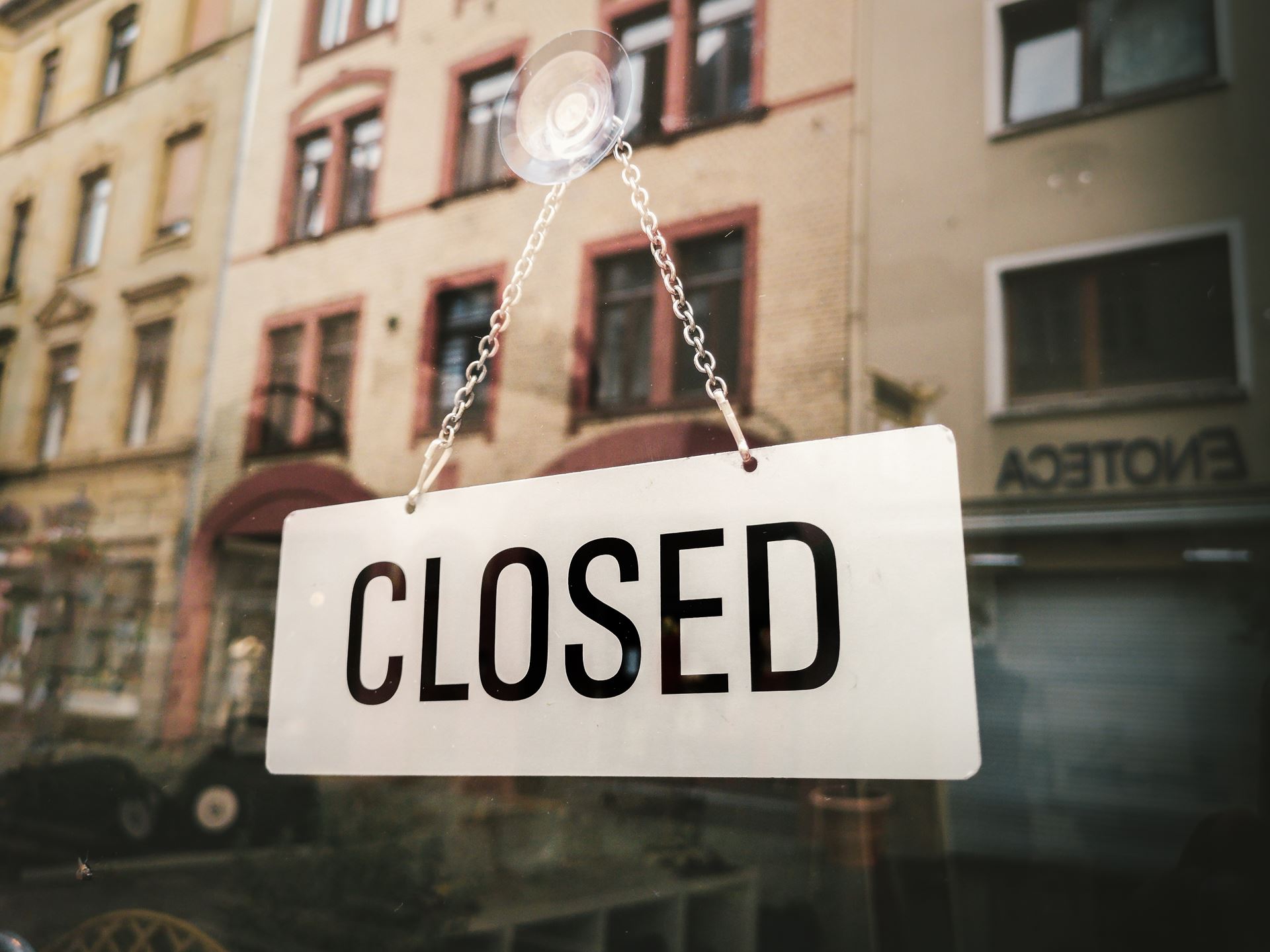 a close up of a street sign hanging off the side of a building